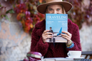 Excited young woman reading journal about journeys