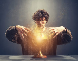 Young man gazing at the glowing crystal ball.