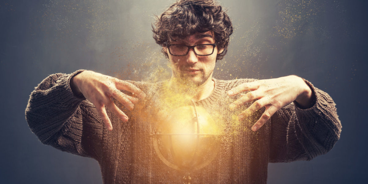 Young man gazing at the glowing crystal ball.